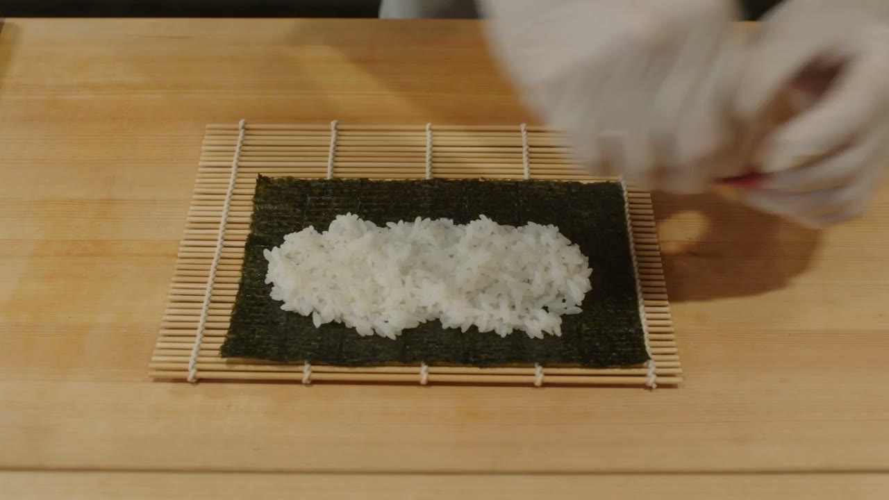 Seedance 2.0 close-up video of gloved hands preparing a sushi roll